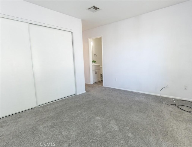 unfurnished bedroom featuring carpet floors, connected bathroom, and a closet