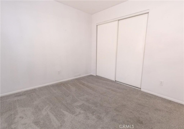 unfurnished bedroom featuring a closet and carpet flooring