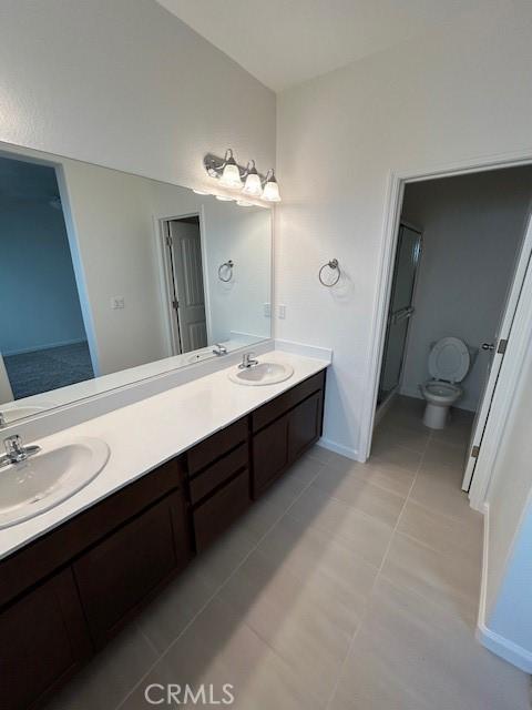 bathroom with vanity, ceiling fan, walk in shower, toilet, and tile patterned floors