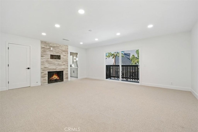 unfurnished living room featuring a tiled fireplace and light carpet