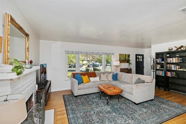 living room with a fireplace and wood-type flooring