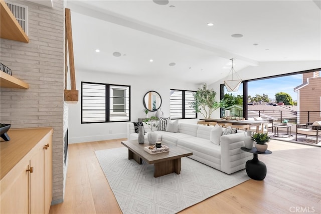 living room with light hardwood / wood-style flooring and lofted ceiling with beams