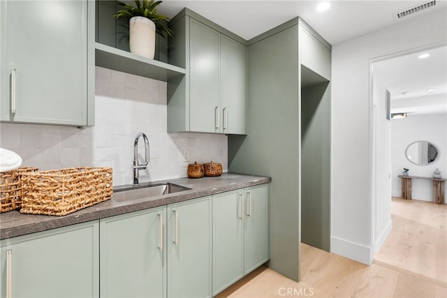 kitchen featuring tasteful backsplash, sink, and light wood-type flooring