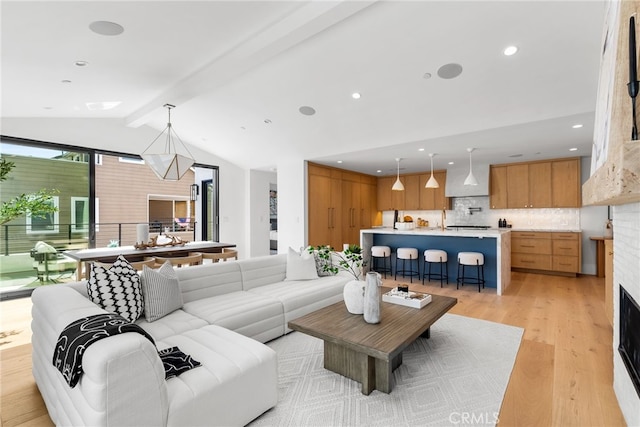 living room featuring light wood-type flooring and vaulted ceiling with beams