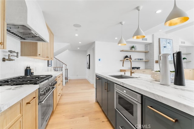 kitchen with pendant lighting, sink, stainless steel appliances, light stone countertops, and custom range hood