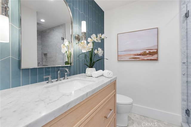 bathroom featuring a shower with door, vanity, and toilet