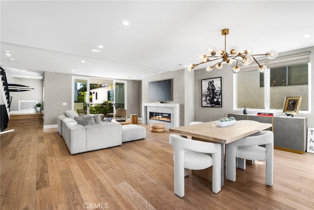 dining area with light hardwood / wood-style flooring and a chandelier