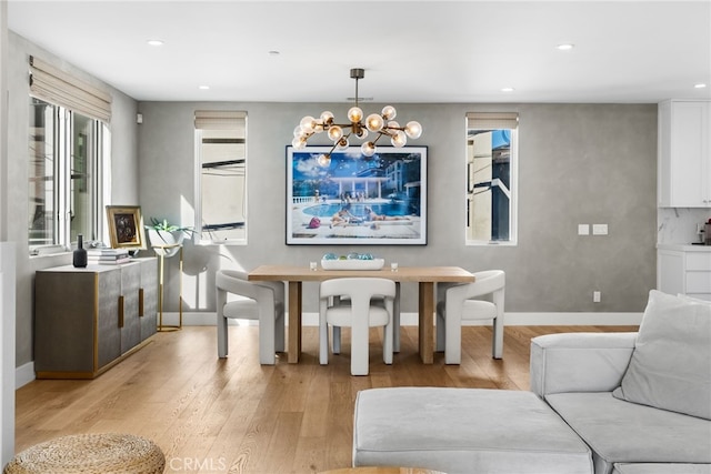 dining room featuring baseboards, recessed lighting, light wood-type flooring, and a notable chandelier