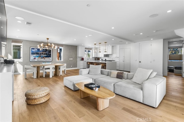 living room featuring light wood-type flooring and a chandelier