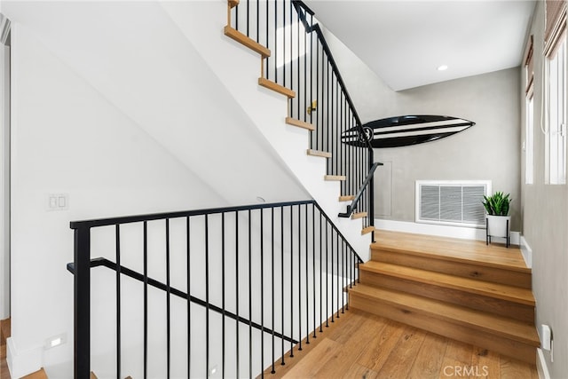 staircase featuring visible vents, wood finished floors, and recessed lighting