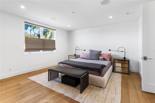 bedroom with baseboards, recessed lighting, and light wood-style floors