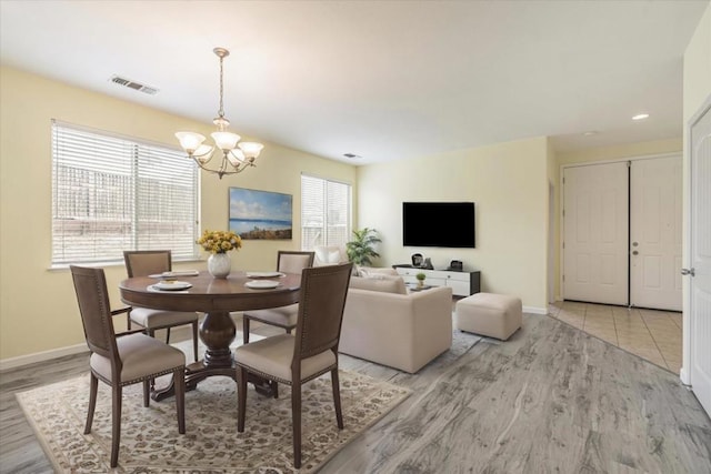 dining area featuring a chandelier and light hardwood / wood-style flooring