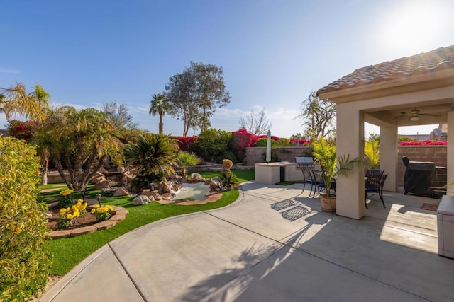 view of patio with ceiling fan and area for grilling