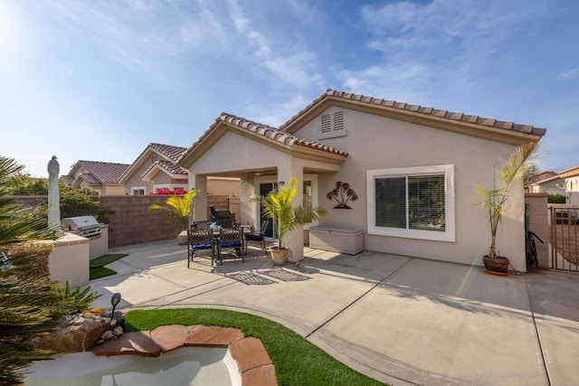 rear view of house featuring exterior kitchen and a patio area