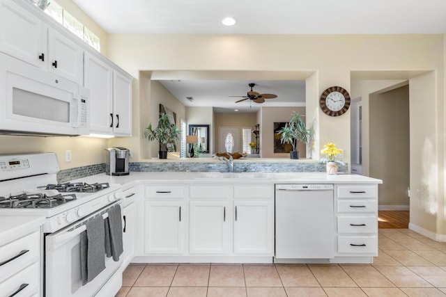 kitchen featuring white cabinetry, white appliances, kitchen peninsula, and sink