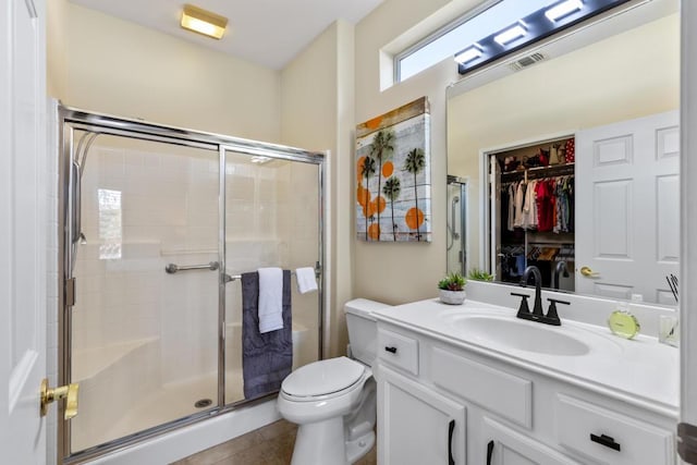 bathroom featuring toilet, vanity, and walk in shower