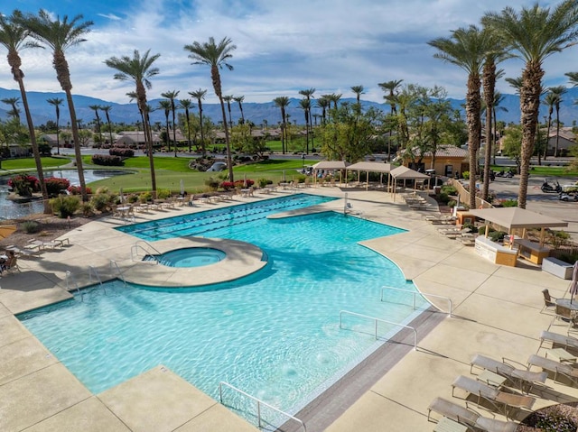 view of swimming pool featuring a hot tub, a gazebo, a mountain view, and a patio area