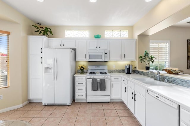 kitchen featuring light tile patterned flooring, sink, white cabinets, and white appliances