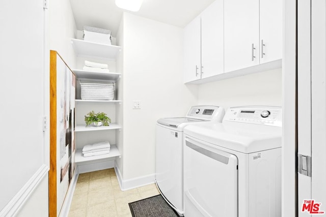 clothes washing area with washer and dryer and cabinets