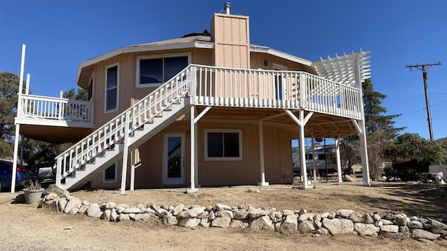 rear view of house with a pergola and a deck