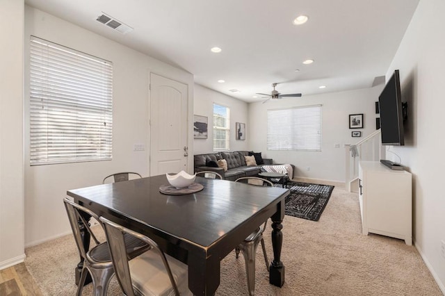 carpeted dining space with ceiling fan