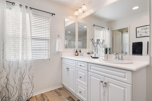 bathroom with vanity, wood-type flooring, and a healthy amount of sunlight