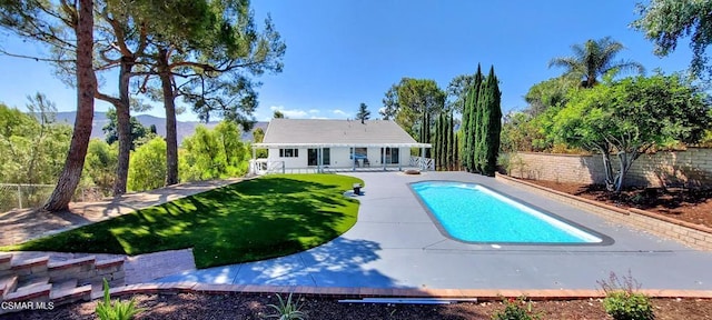 view of pool with a yard, an outdoor structure, and a patio area