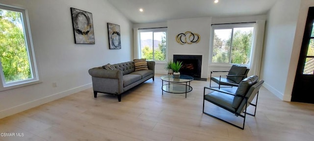 living area featuring lofted ceiling and light hardwood / wood-style floors