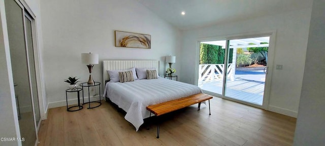 bedroom with lofted ceiling, access to exterior, and light hardwood / wood-style flooring