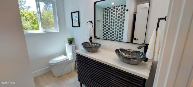 bathroom featuring vanity, toilet, and walk in shower