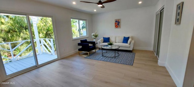 living room featuring ceiling fan and light hardwood / wood-style flooring