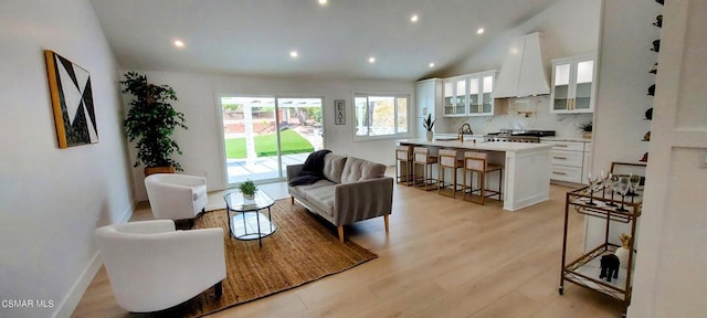 living room with lofted ceiling and light hardwood / wood-style floors