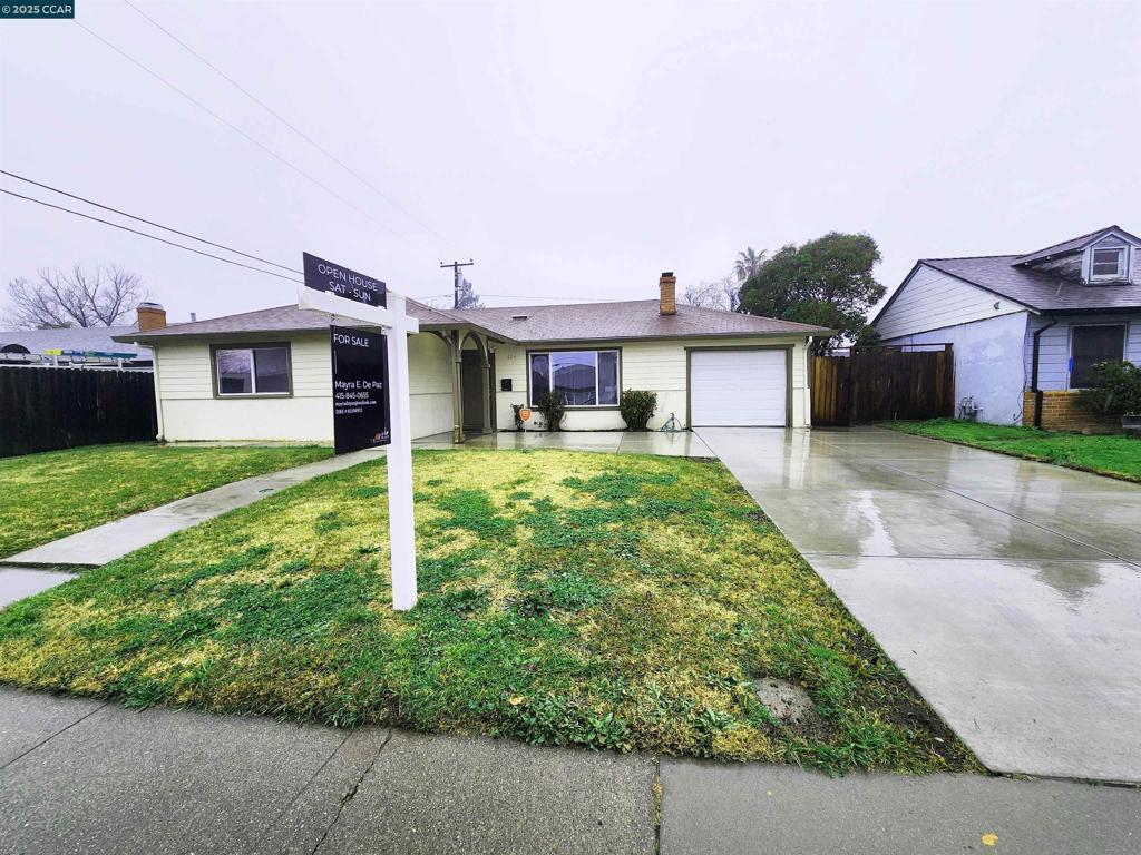 ranch-style house featuring a garage and a front yard