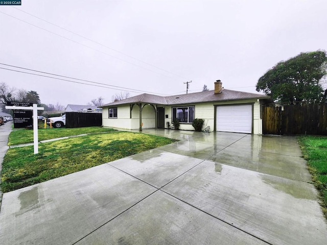 ranch-style home with a garage and a front lawn