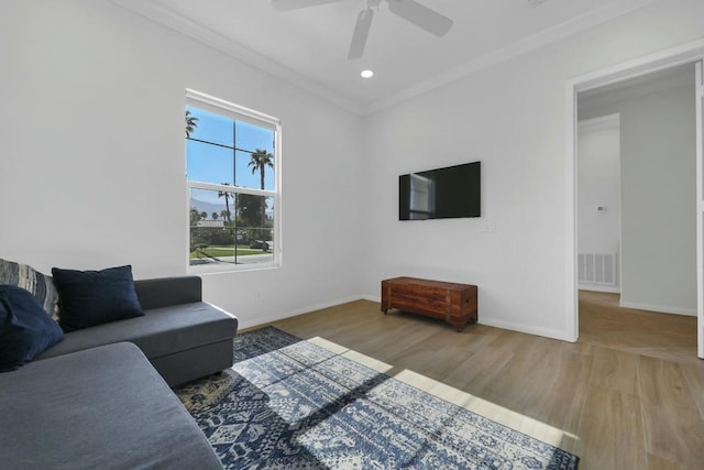 living room featuring hardwood / wood-style floors, crown molding, and ceiling fan