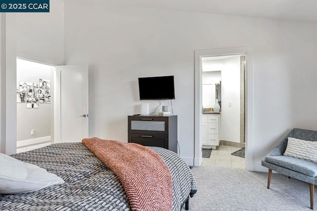 bedroom with light colored carpet and ensuite bath