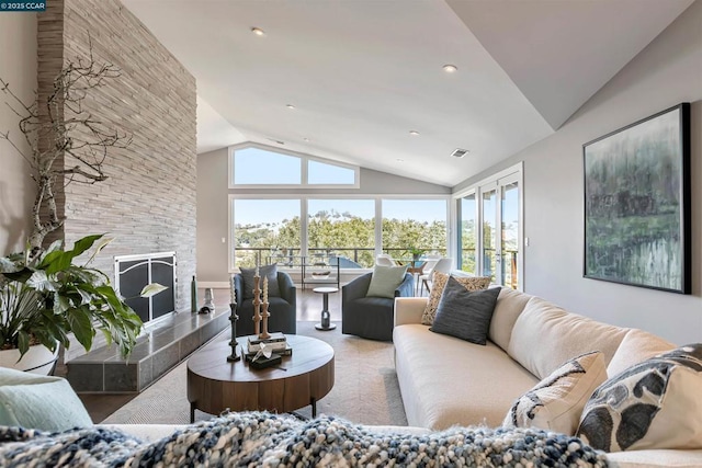 living room featuring lofted ceiling and a tiled fireplace