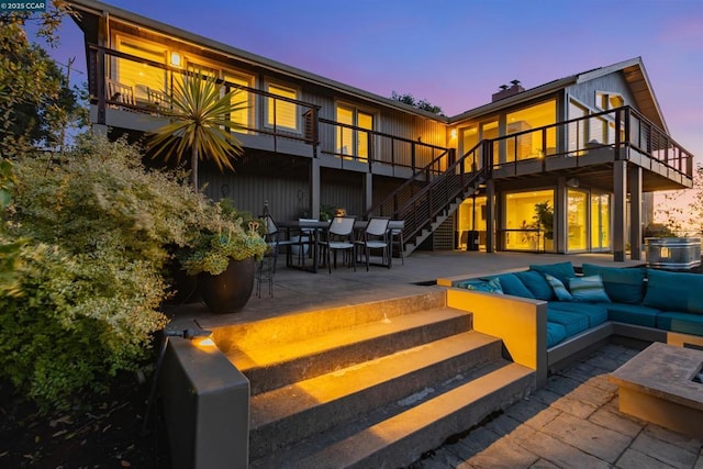 back house at dusk featuring an outdoor hangout area and a patio area