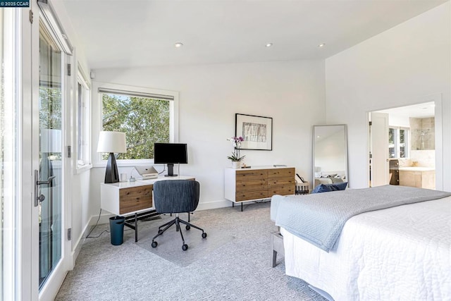 bedroom with ensuite bathroom, lofted ceiling, and light carpet