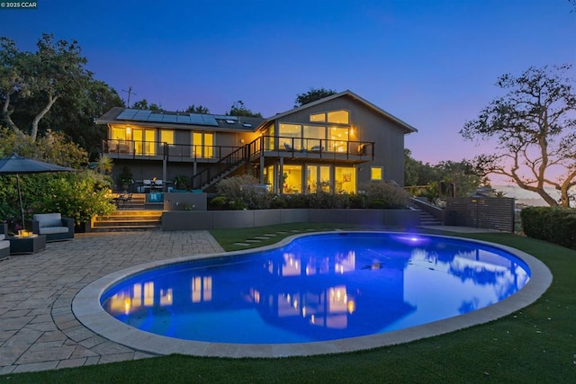 pool at dusk with a patio area