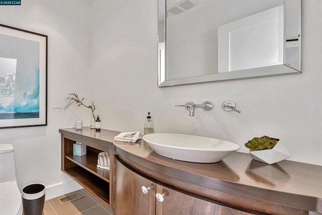 bathroom featuring vanity, tile patterned flooring, and toilet