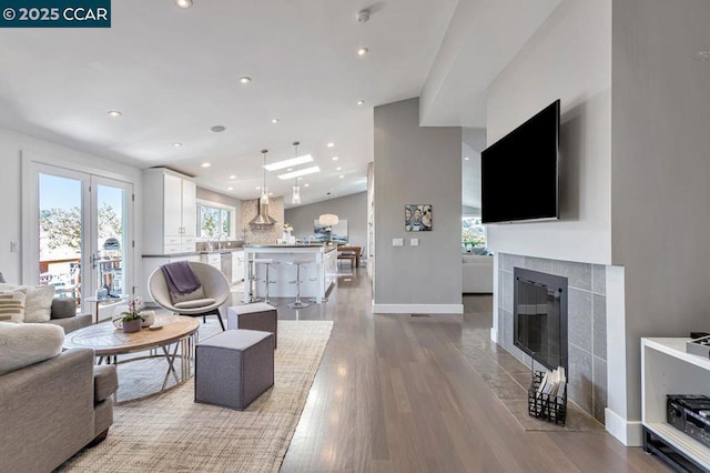 living room featuring a tiled fireplace and light wood-type flooring