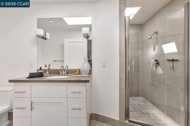 bathroom featuring vanity, toilet, and a shower with shower door