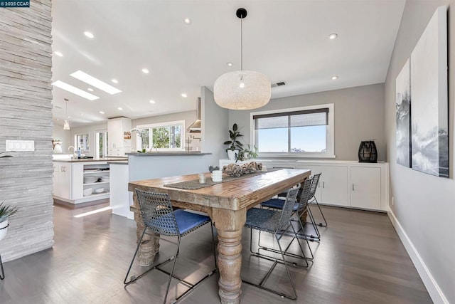 dining room with a skylight and dark wood-type flooring