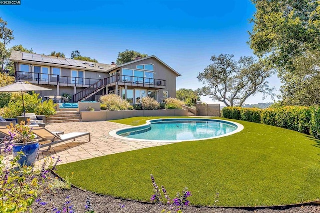 view of pool with a lawn and a patio area