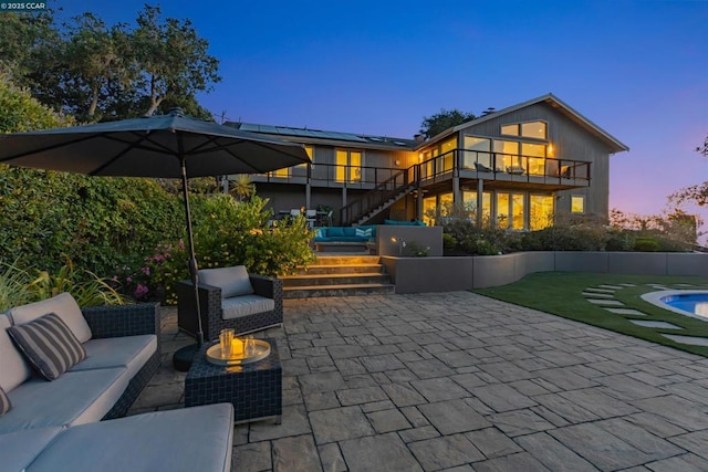 patio terrace at dusk featuring an outdoor living space with a fire pit