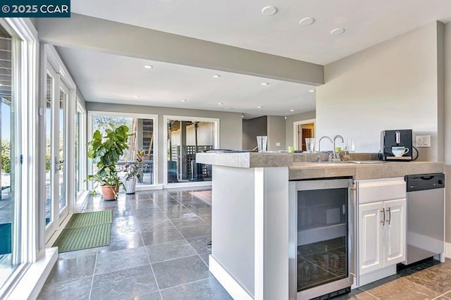 kitchen featuring white cabinetry, sink, and beverage cooler