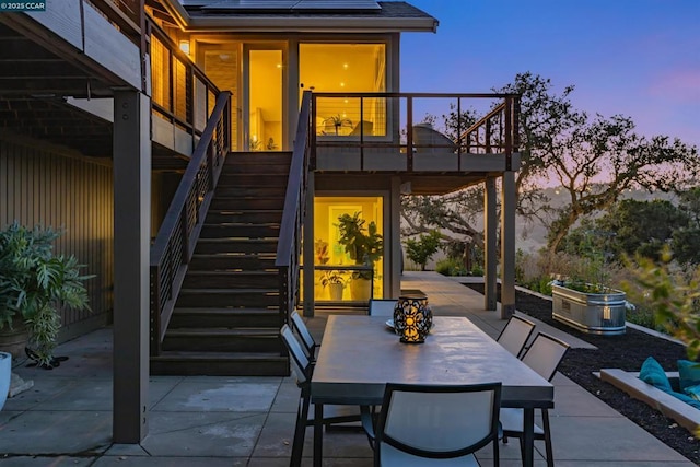 patio terrace at dusk featuring a balcony