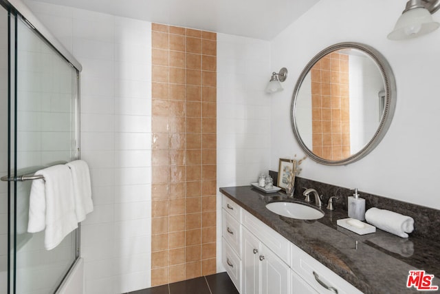 bathroom with vanity and enclosed tub / shower combo