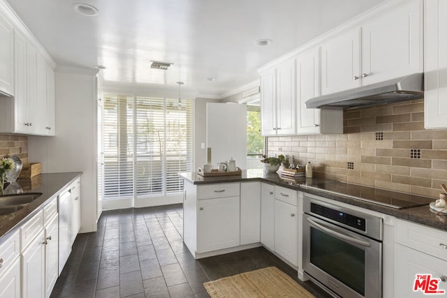 kitchen featuring tasteful backsplash, black electric stovetop, white cabinets, kitchen peninsula, and stainless steel oven